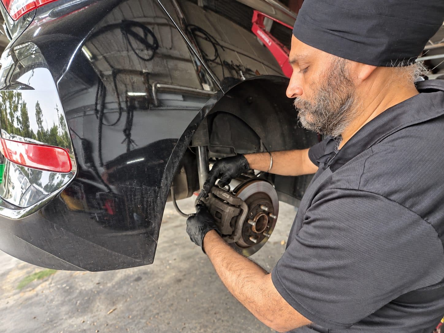Mechanic fitting a brake caliper during a brake service