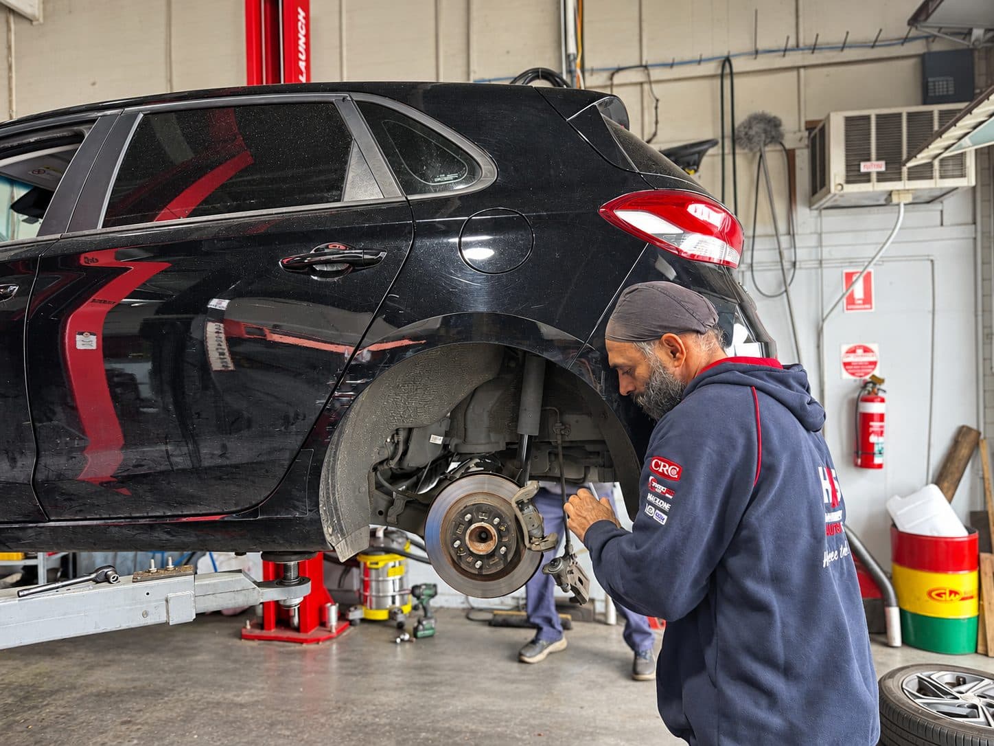 Mechanic inspecting brakes and suspension with the wheel off