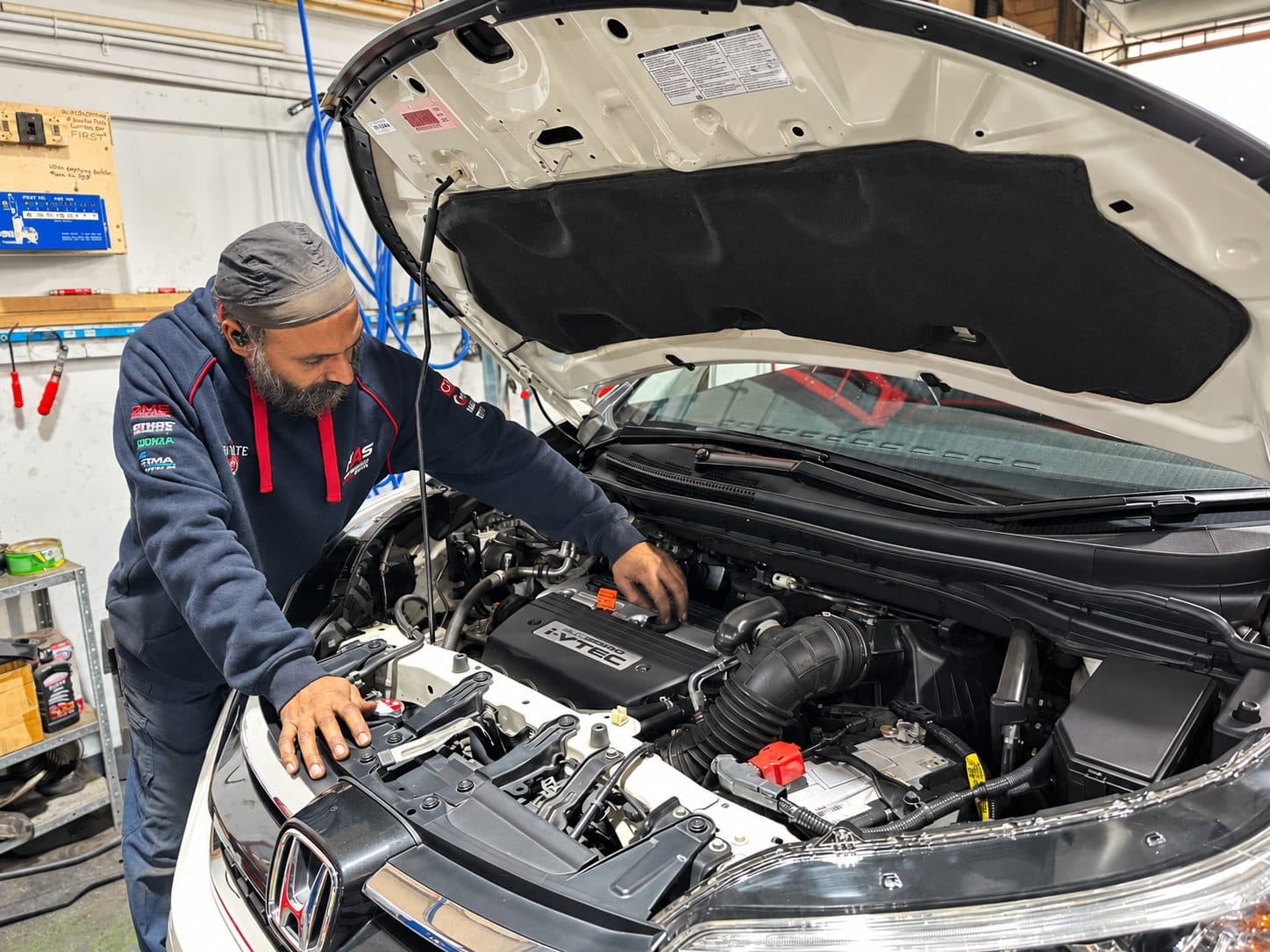 Mechanic checking an engine bay during a logbook service