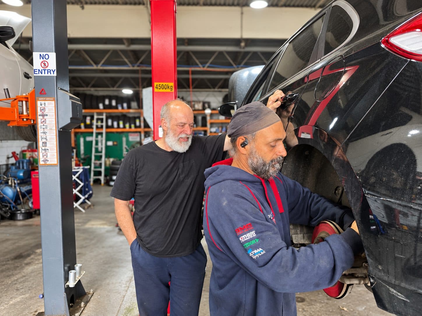 Two mechanics working on a wheel service at Switch Gear Automotive, Riverstone